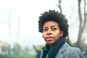 woman standing outside in a winter coat with a half smile on her face